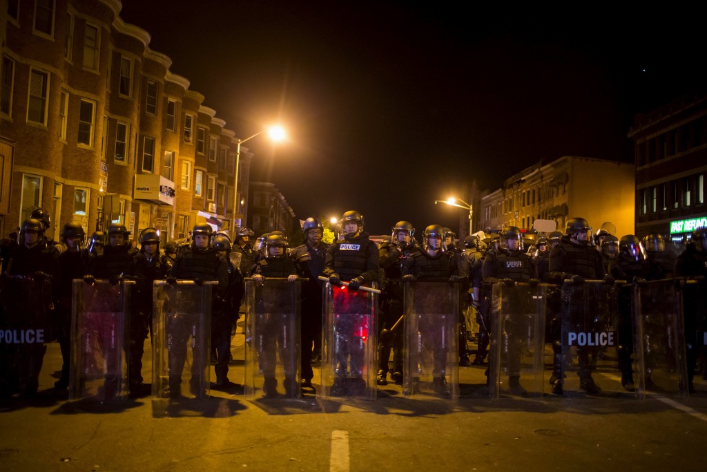 Policías reunidos en una calle poco antes de la hora del toque de queda en Baltimore, EEUU