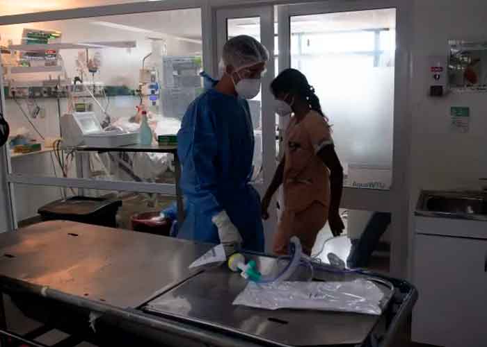 Personal médico desinfectando el área donde murió el paciente con la variante delta   