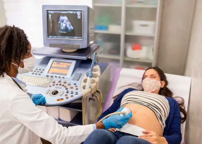 Una enfermera haciendo un ultrasonido a una mujer embarazada