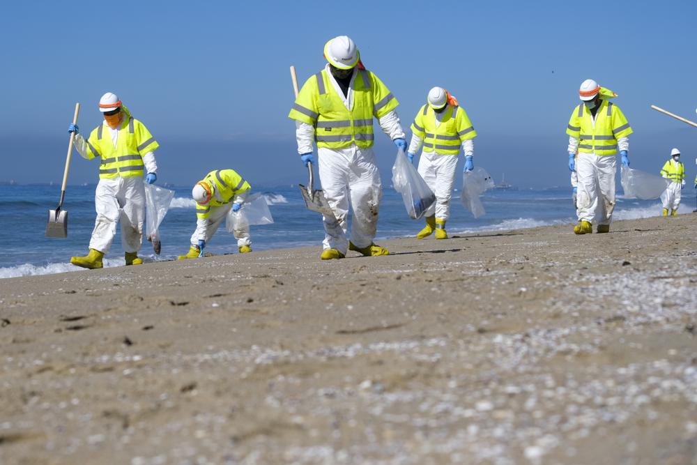 imagenes de trabajadores limpiando la zona producto del derrame de petróleo